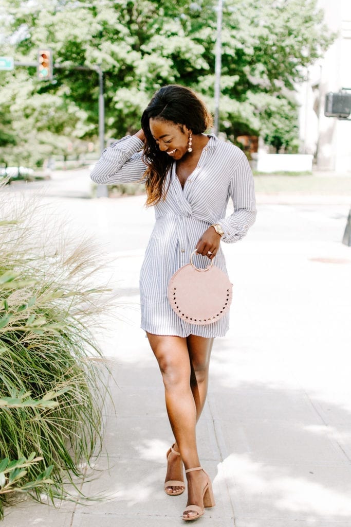 Tomi Obebe is wearing a striped dress, nude heels and blush bag