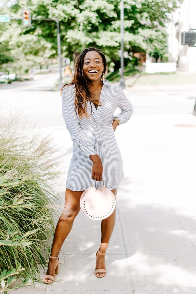 Tomi Obebe is wearing a striped dress, nude heels and blush circle bag