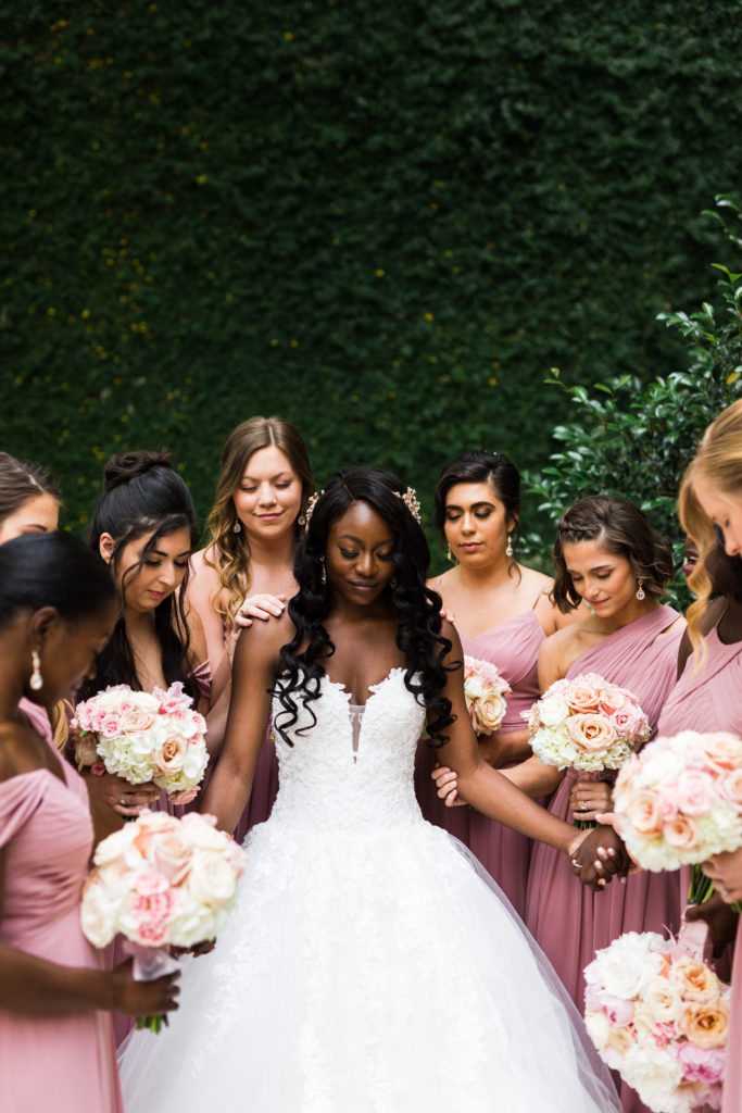 Bridesmaids gathered around the bride for prayer before the wedding ceremony