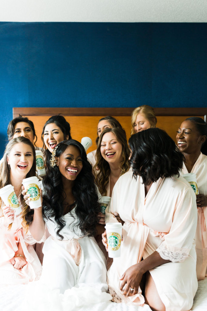Bridal getting ready photos with her bridesmaids in matching robes featuring personalized Starbucks cups