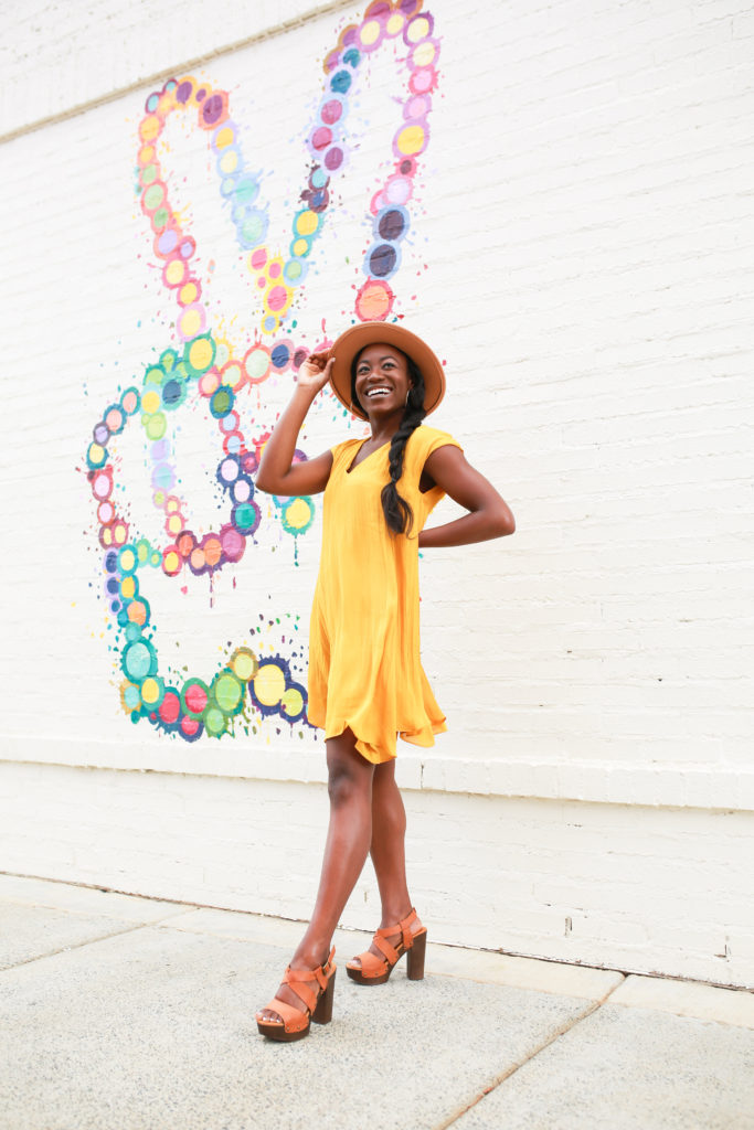 Charlotte fashion blogger posing in front of South End peace sign mural in front of Flower Child | GoodTomiCha 