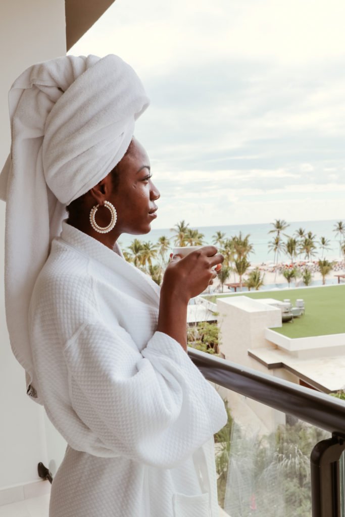 Black travel blogger, goodtomicha on the patio of her ocean-view room in hyatt zilara cap cana 