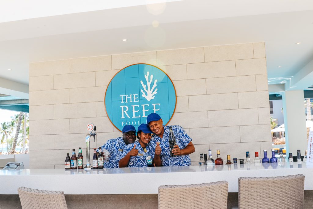 Lovely bartenders smiling while working on the happy hour drinks at the pool side bar: the reef