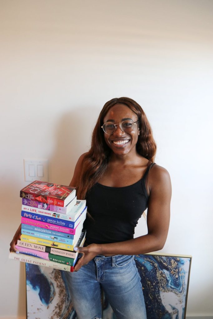 woman smiling and holding books for Q1 book review 2021