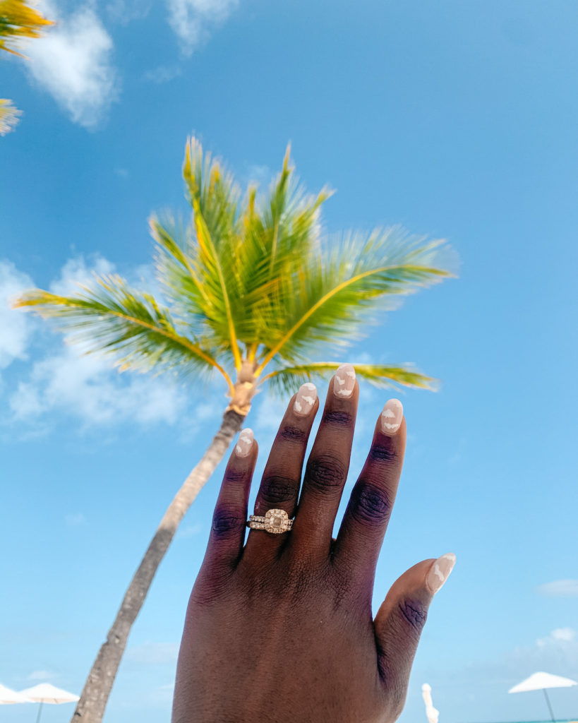 womans hand with ring with sky on the background 