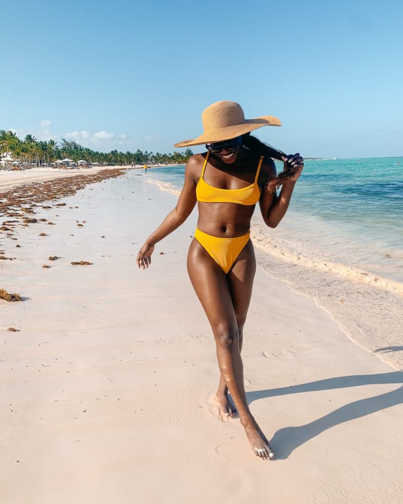 woman at the beach and wearing yellow two piece for dr outfit roundup