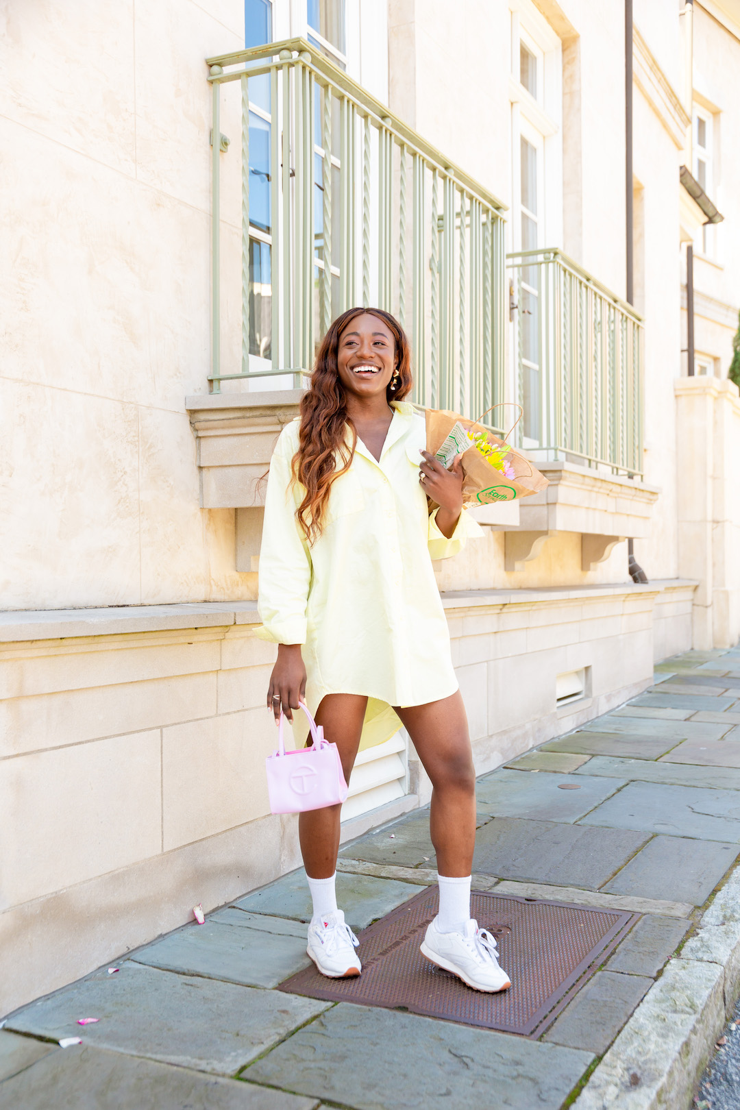 woman smiling and wearing white shoes and yellow dress 
