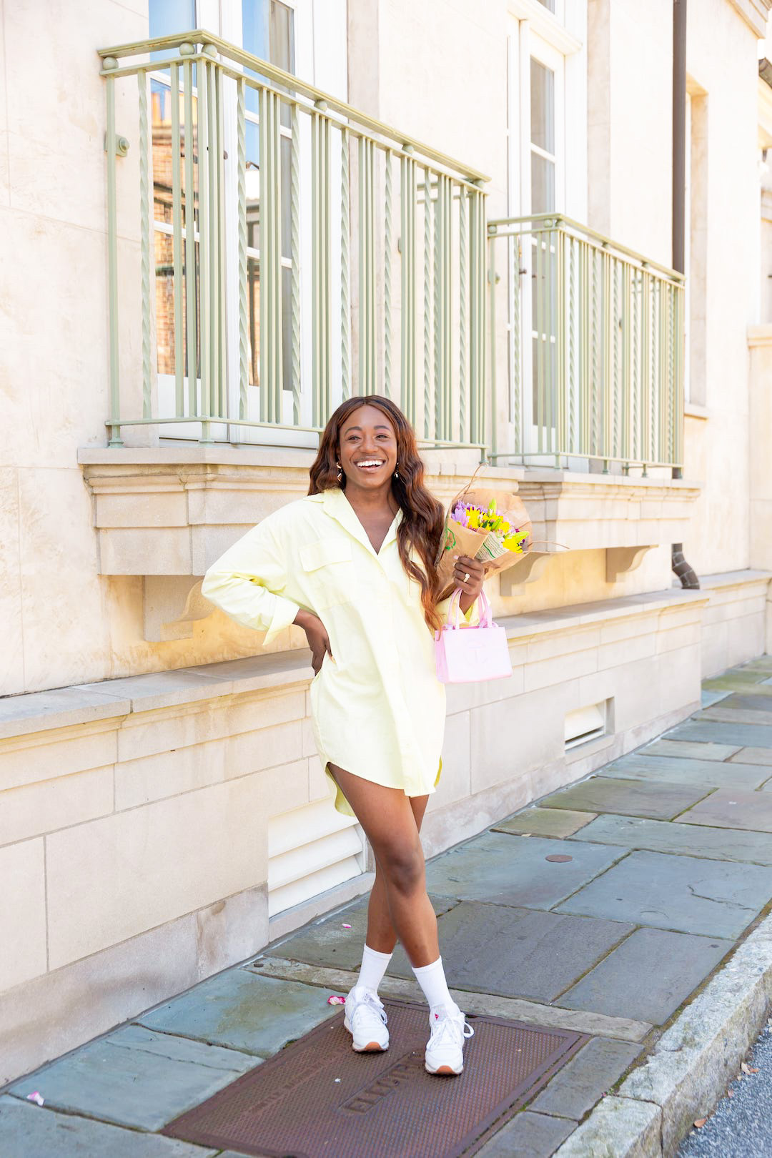 woman smiling and wearing yellow dress and white shoes