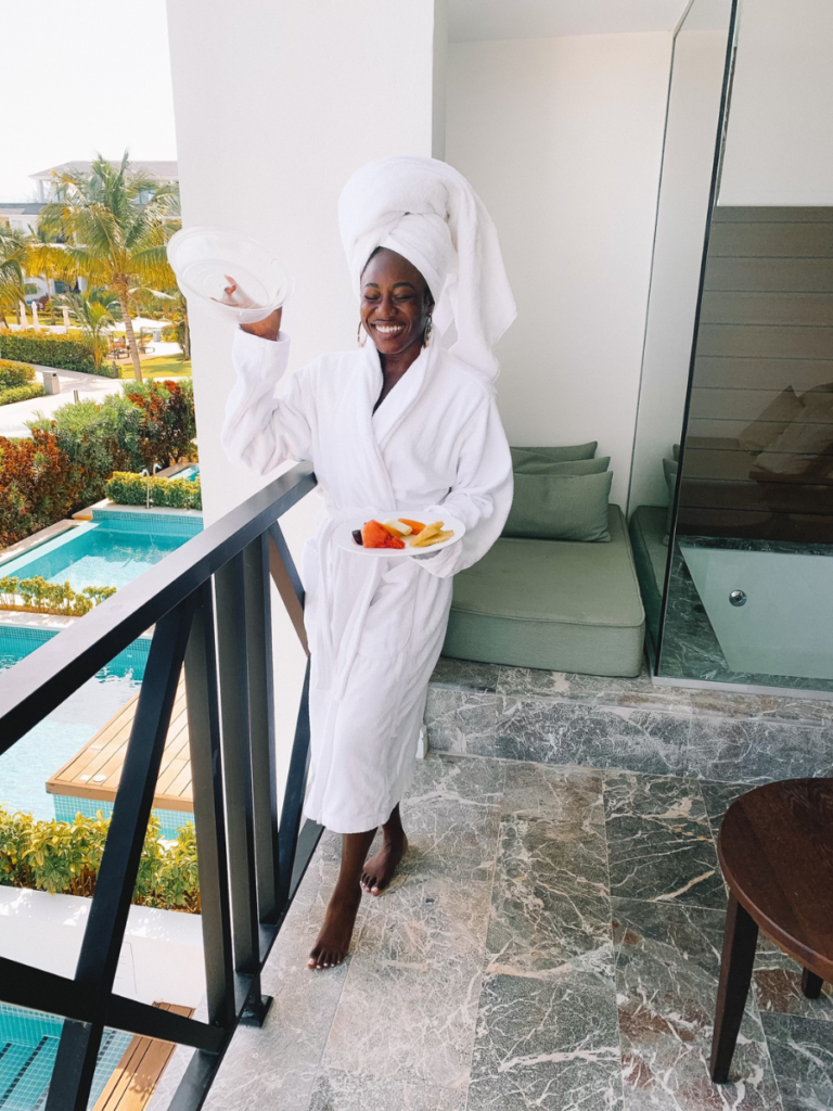 goodtomicha enjoying fresh fruit on a balcony in a white robe