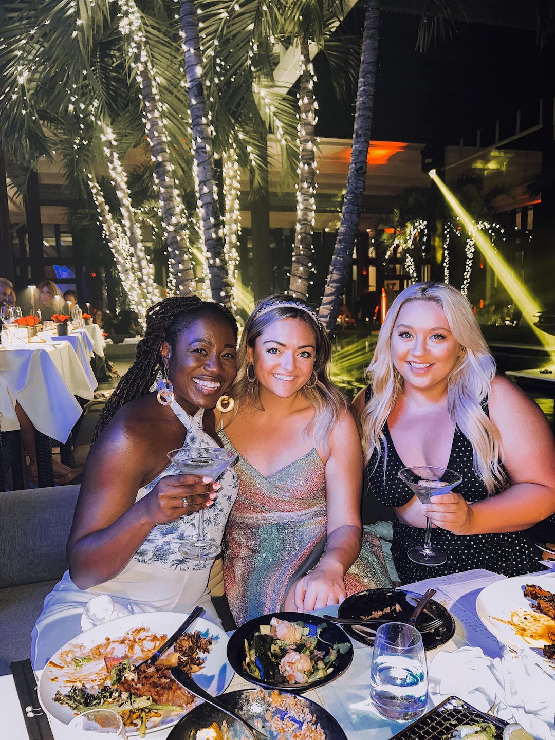 three women holding martinis at dinner in Miami