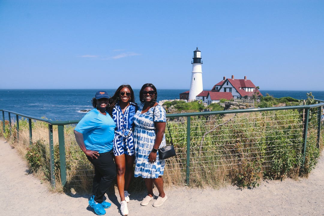 There women standing in front of lighthouse in Maine