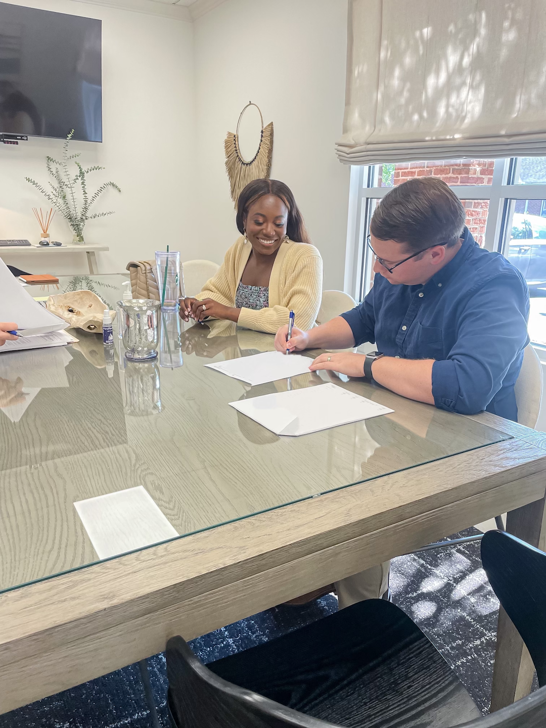 man and woman signing closing docs for first home