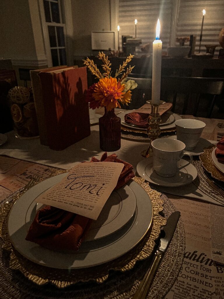 dark academia dinner party table scape with name cards placed on vintage papers