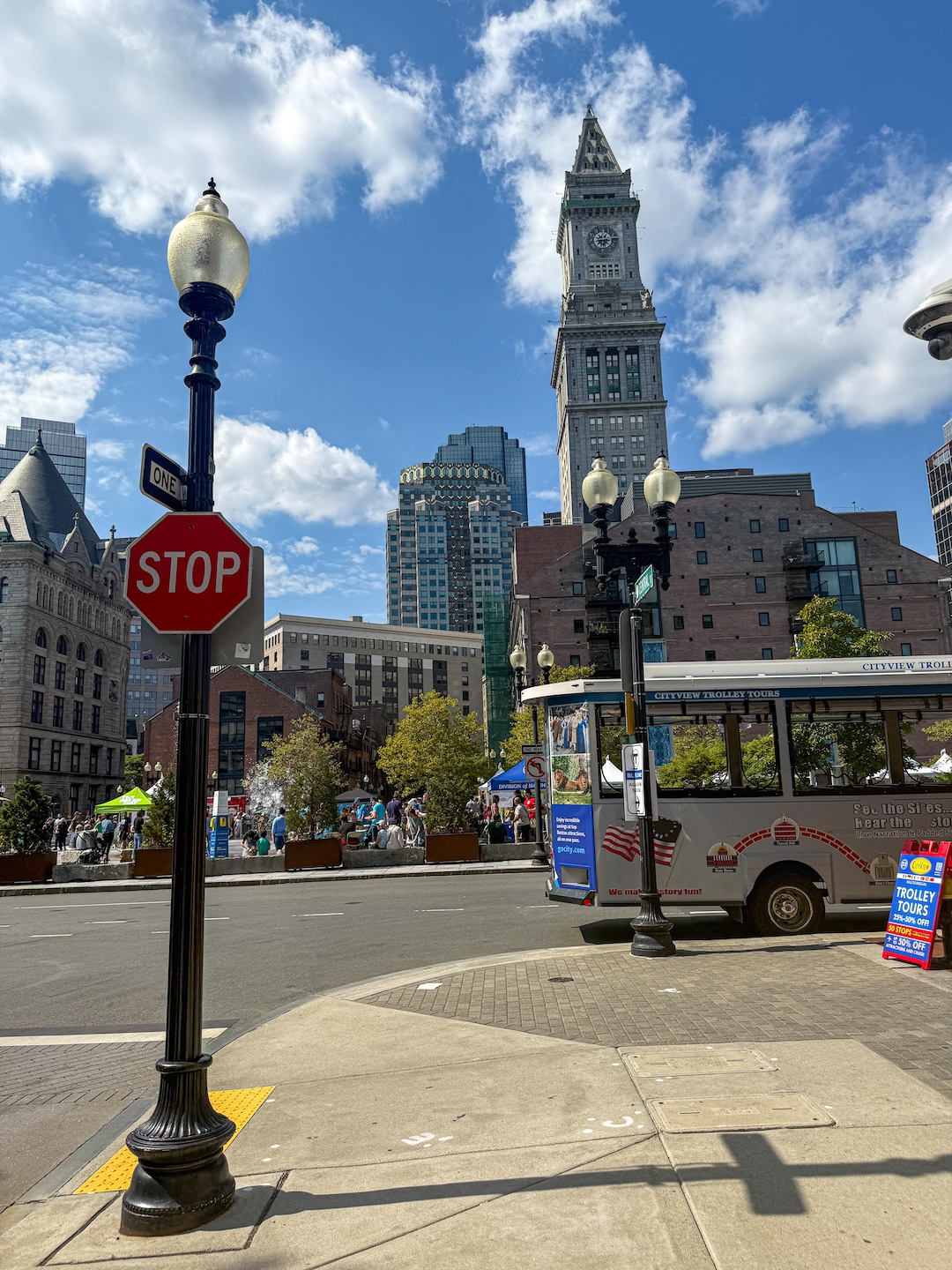 bustling street view of Boston featuring a street car on a sunny day | GoodTomiCha.com